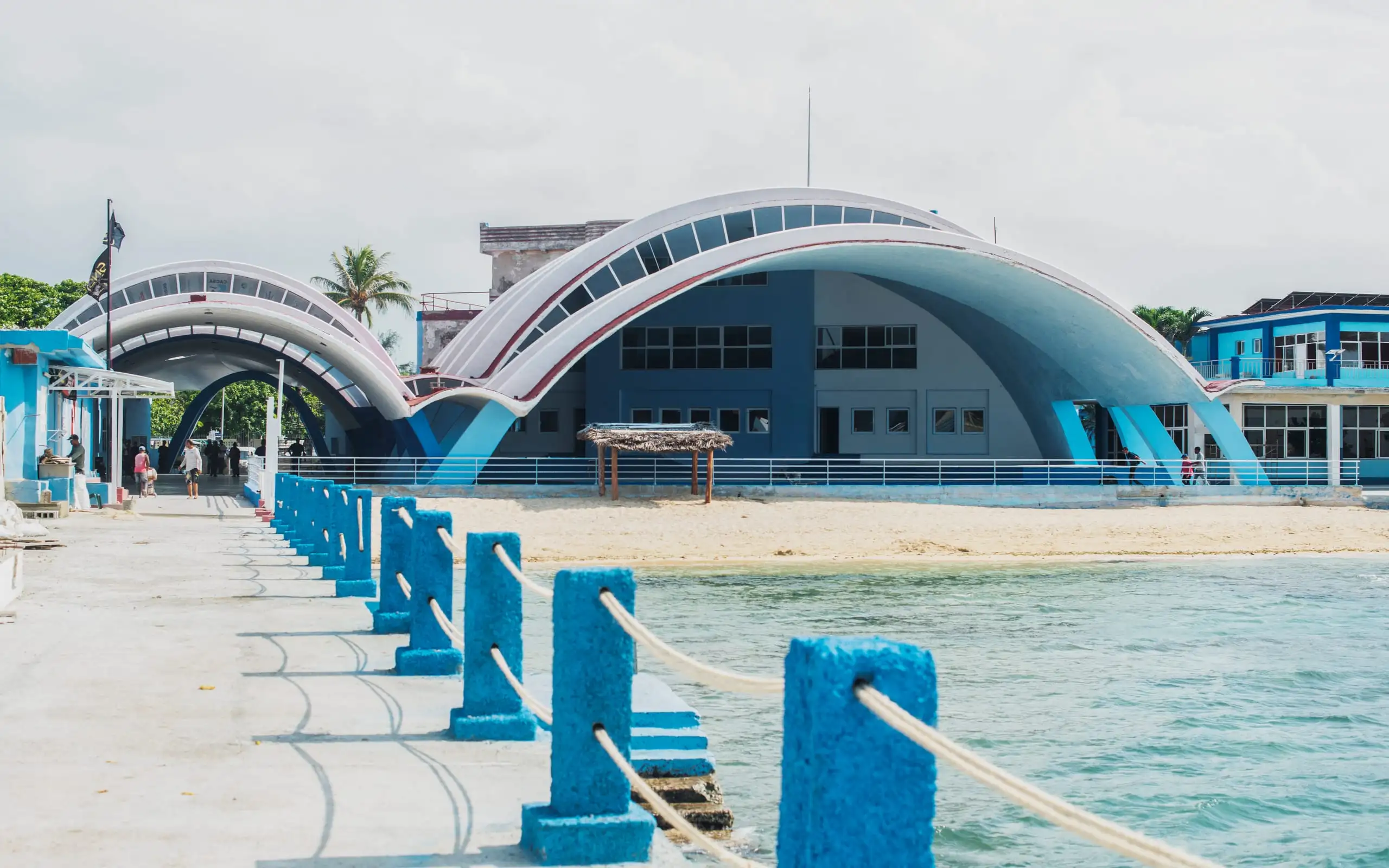 Pasarela de arcos azules sobre el mar hacia la instalación