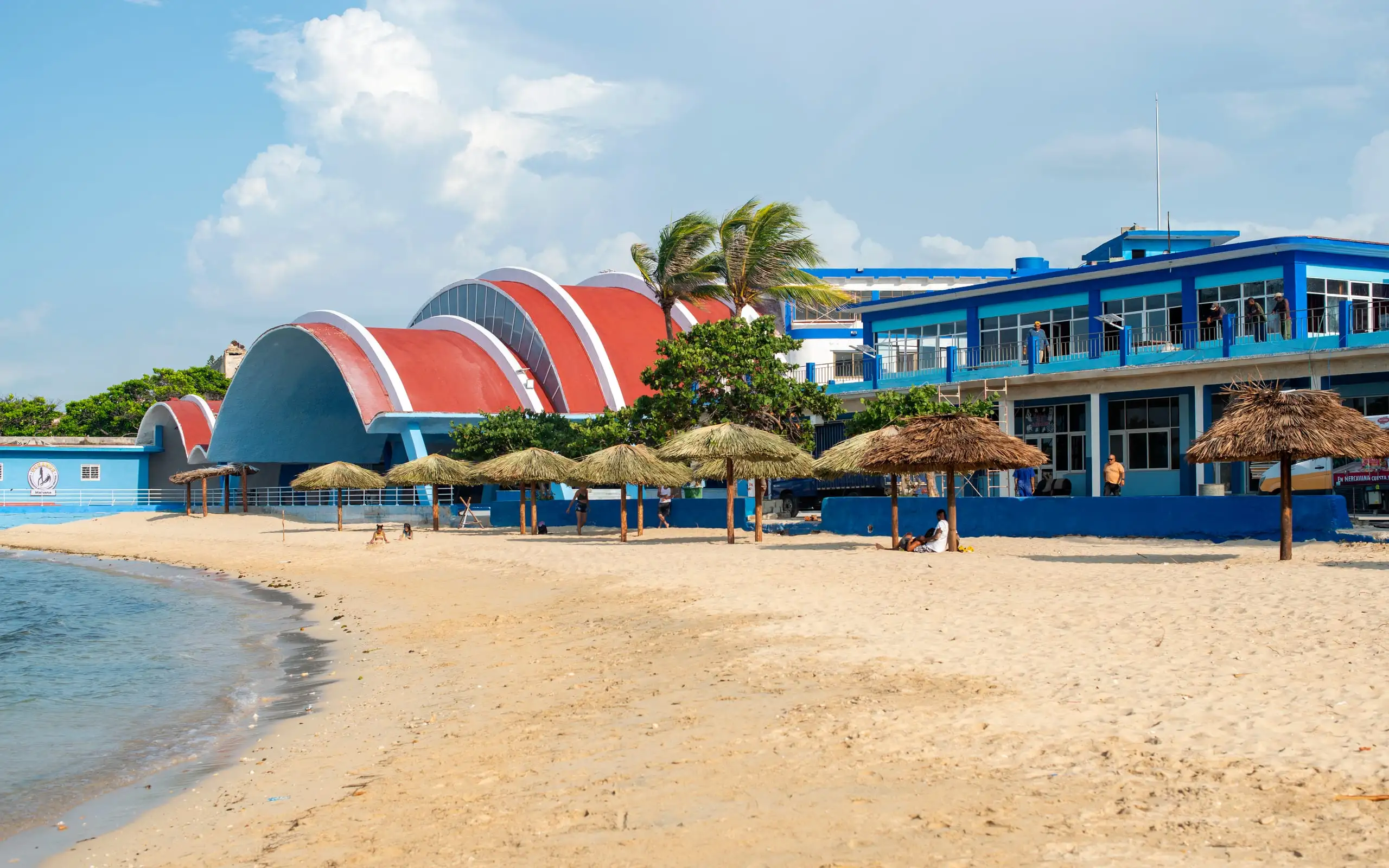 Playa con sombrillas y la cúpula del centro al fondo