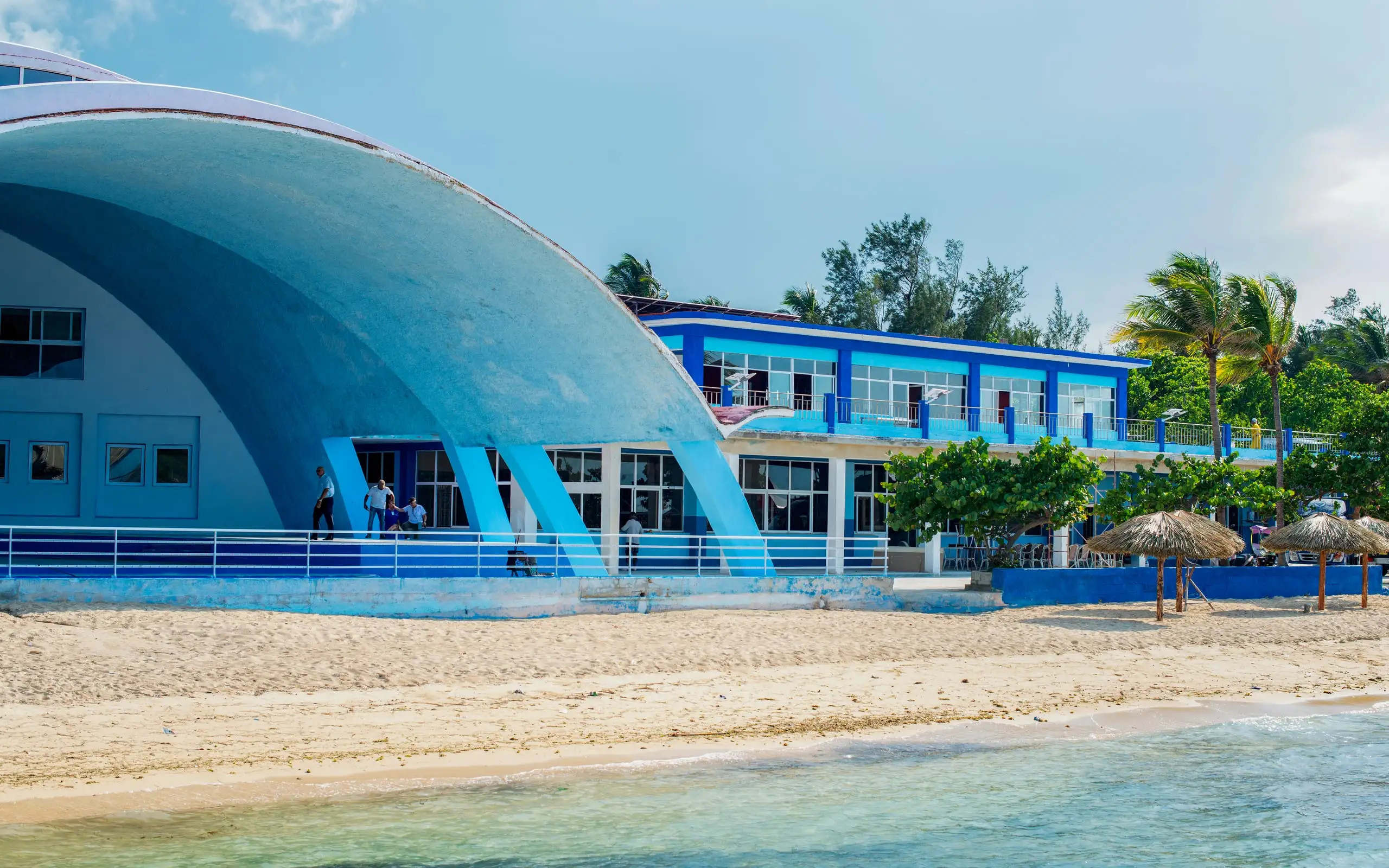 Gran cúpula azul junto a la playa y las palmeras